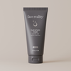 Dark gray tube of Face Reality hydraCalm Mask against light beige background