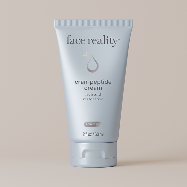 Tube of Face Reality cran-peptide cream on a beige background