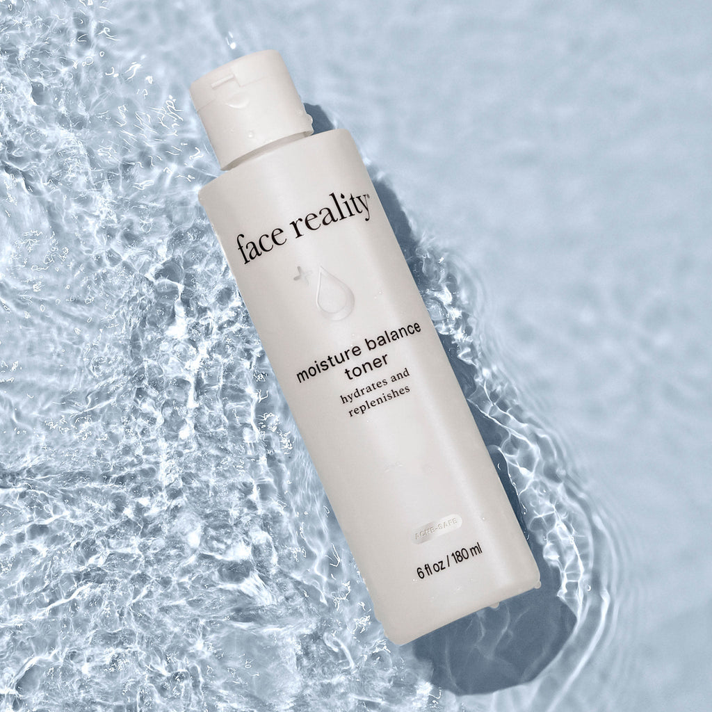 Face Reality moisture balance toner bottle laying flat against light blue pool of water